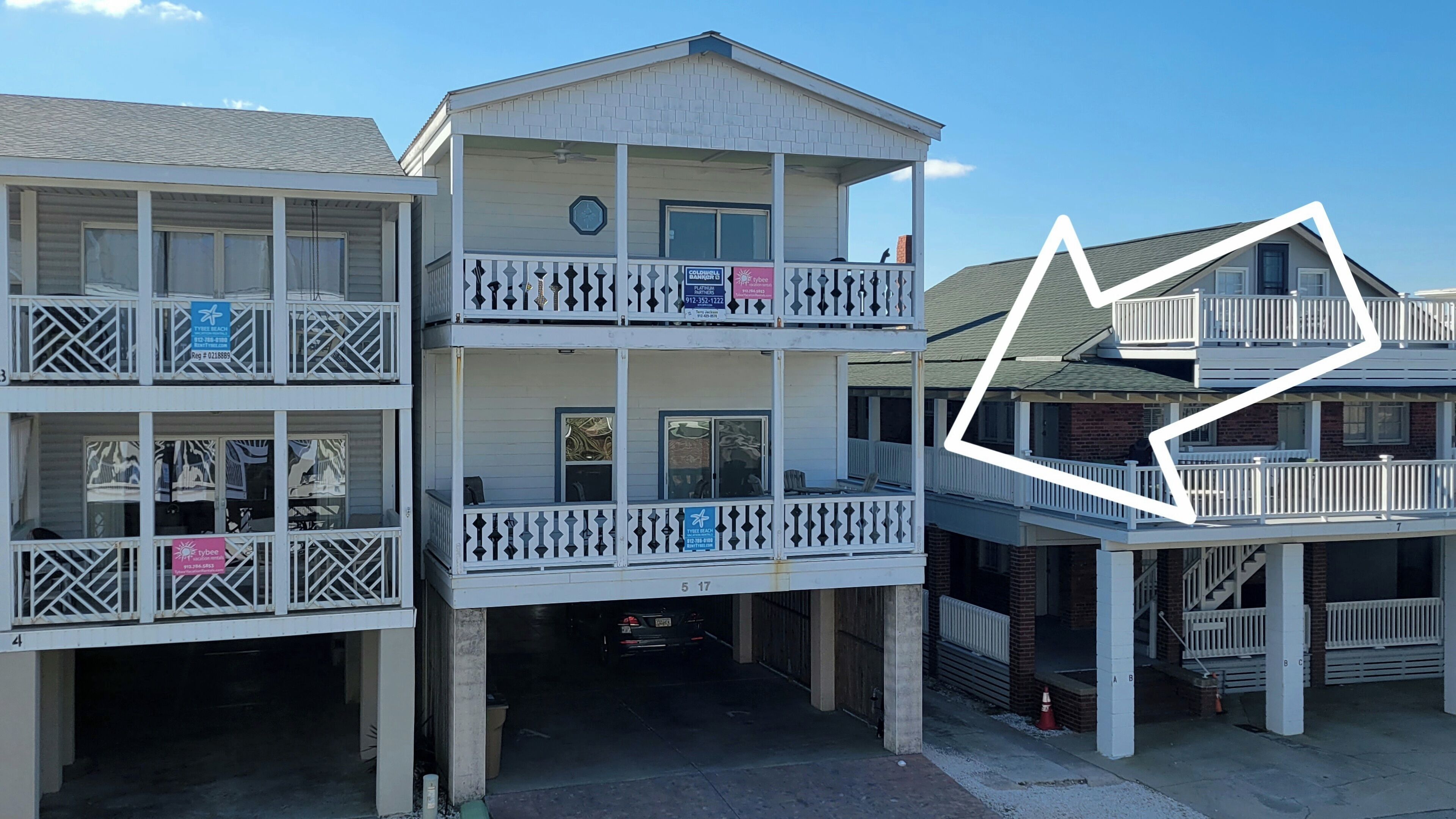 Ein mehrstöckiges Gebäude mit Balkonen, einer sichtbaren Telefonnummer und einem Schild für Tybee Beach.