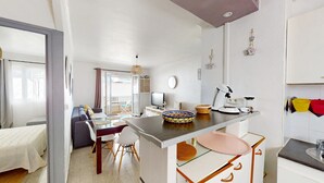 A compact living space with a kitchenette, dining area, and a small seating area.