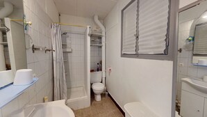 A compact bathroom with a bathtub, toilet, and shower area.