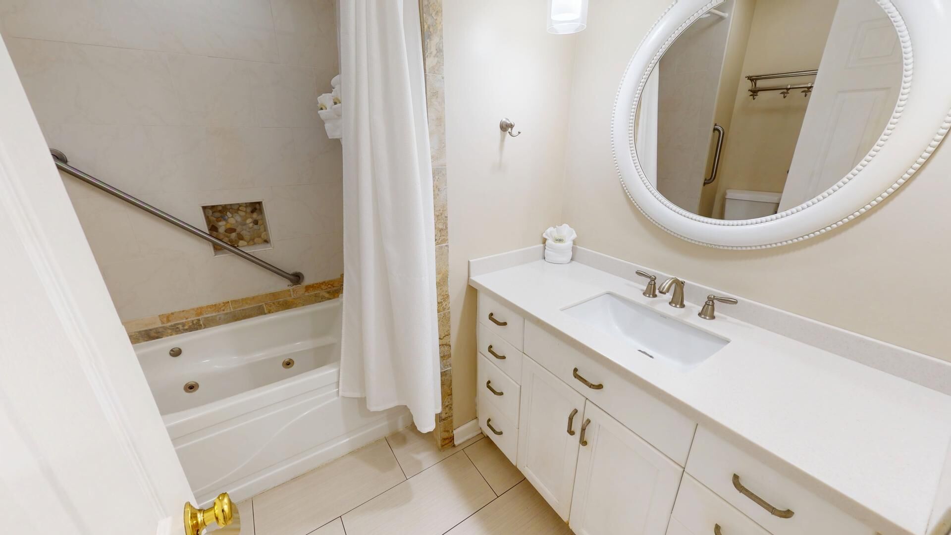 A bathroom with a bathtub, a shower, a sink with a mirror, and a toilet.