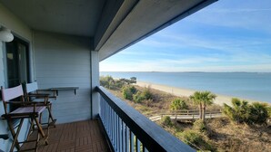 Uma varanda com vista para a praia e o oceano.