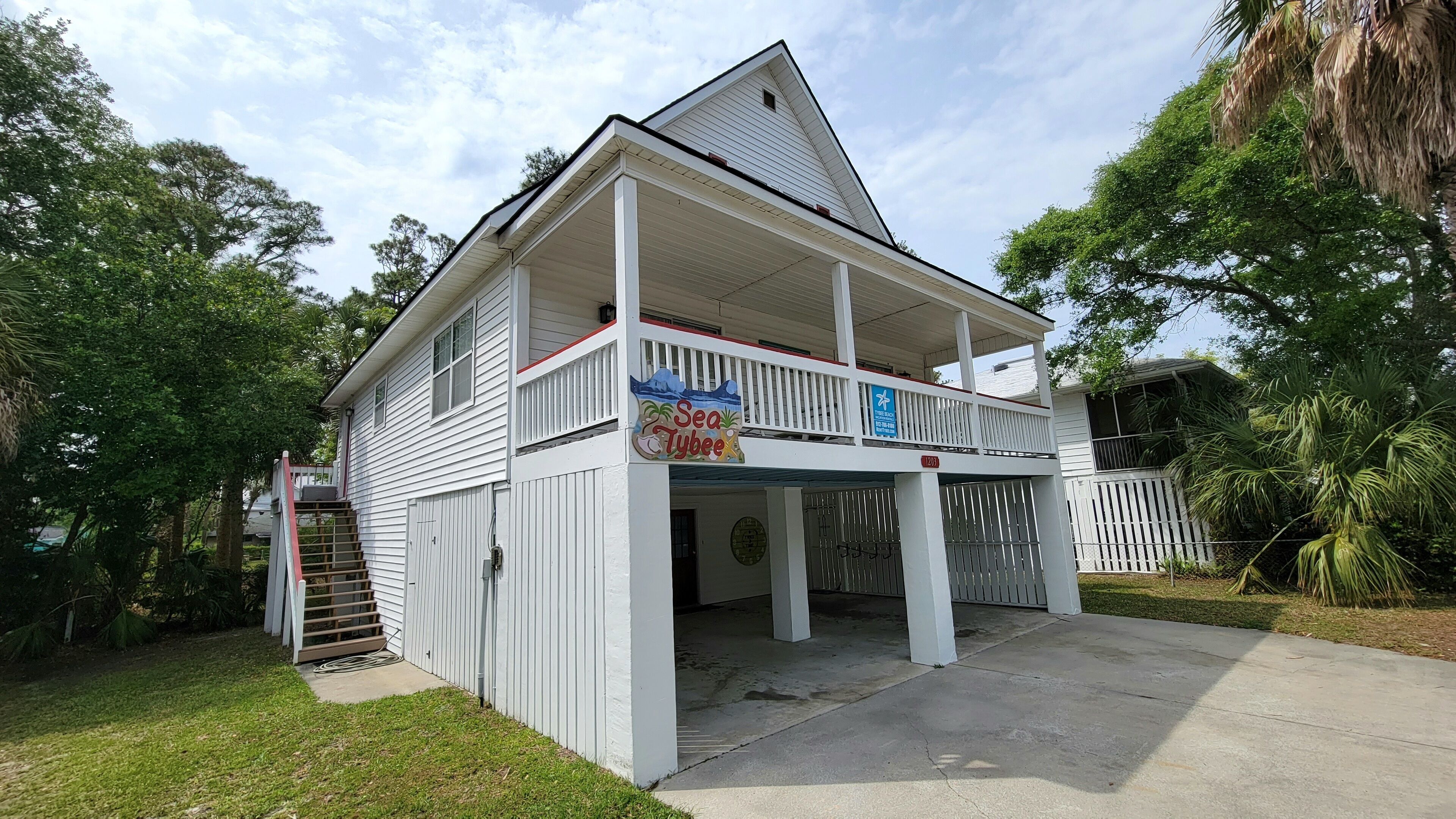 A two-story house with a covered front porch and a balcony.