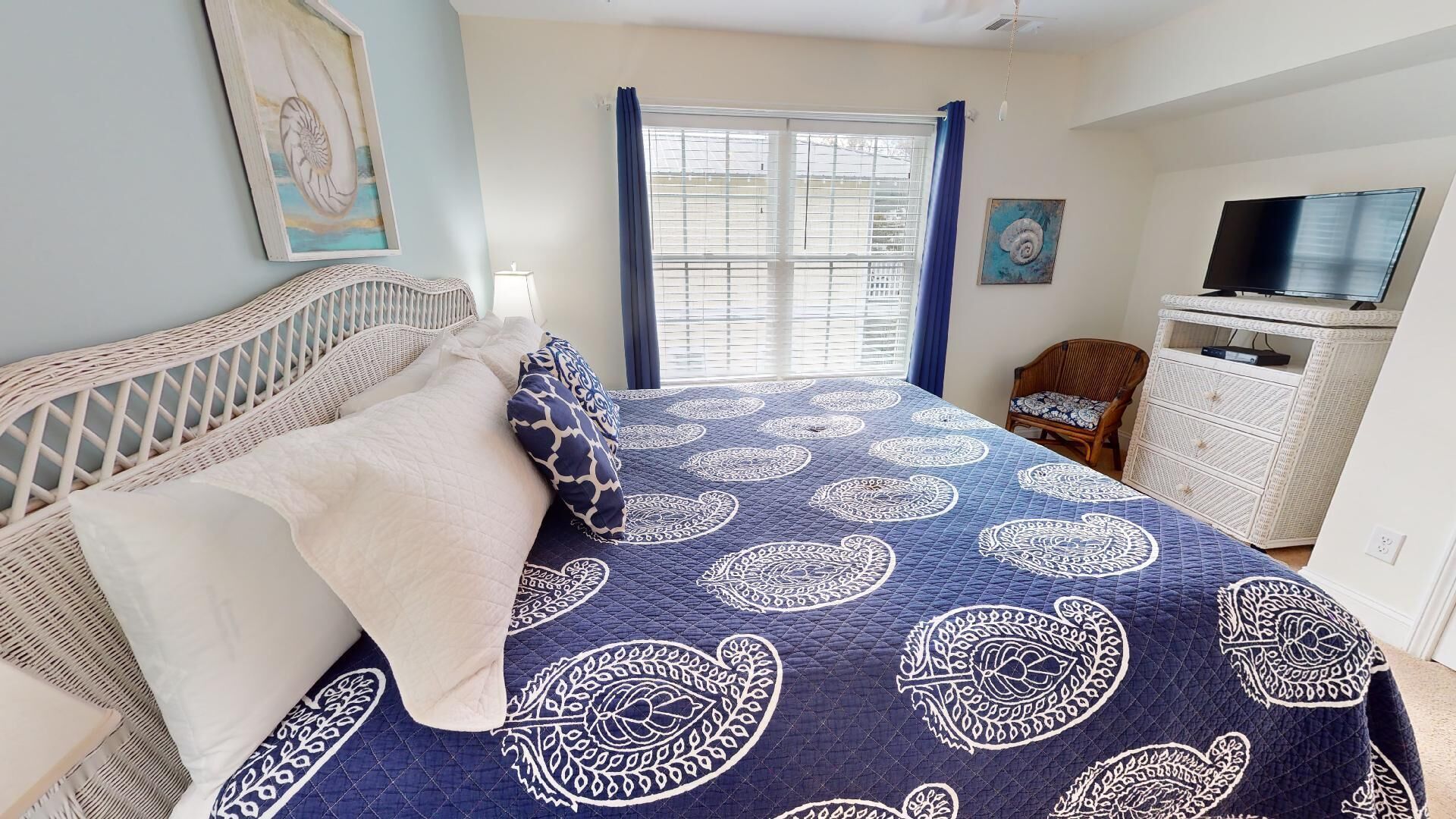 A bedroom with a bed, a television, a dresser, and a chair.