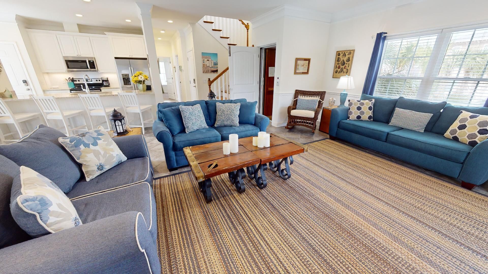 Una sala de estar moderna con un sofá azul, una mesa de centro y un tapete estampado.