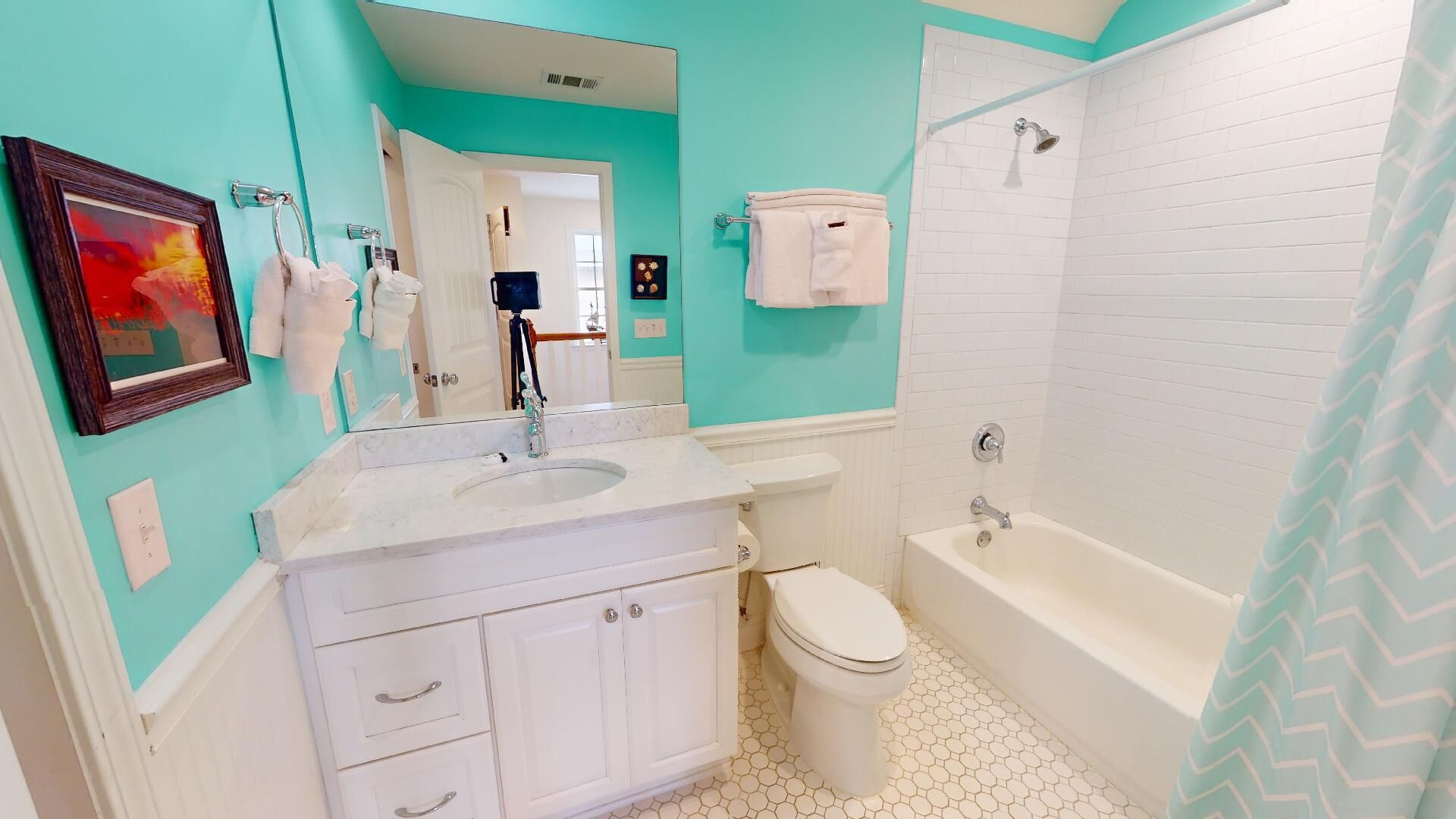 A bathroom with a white sink, toilet, and bathtub, and a mirror above the sink.