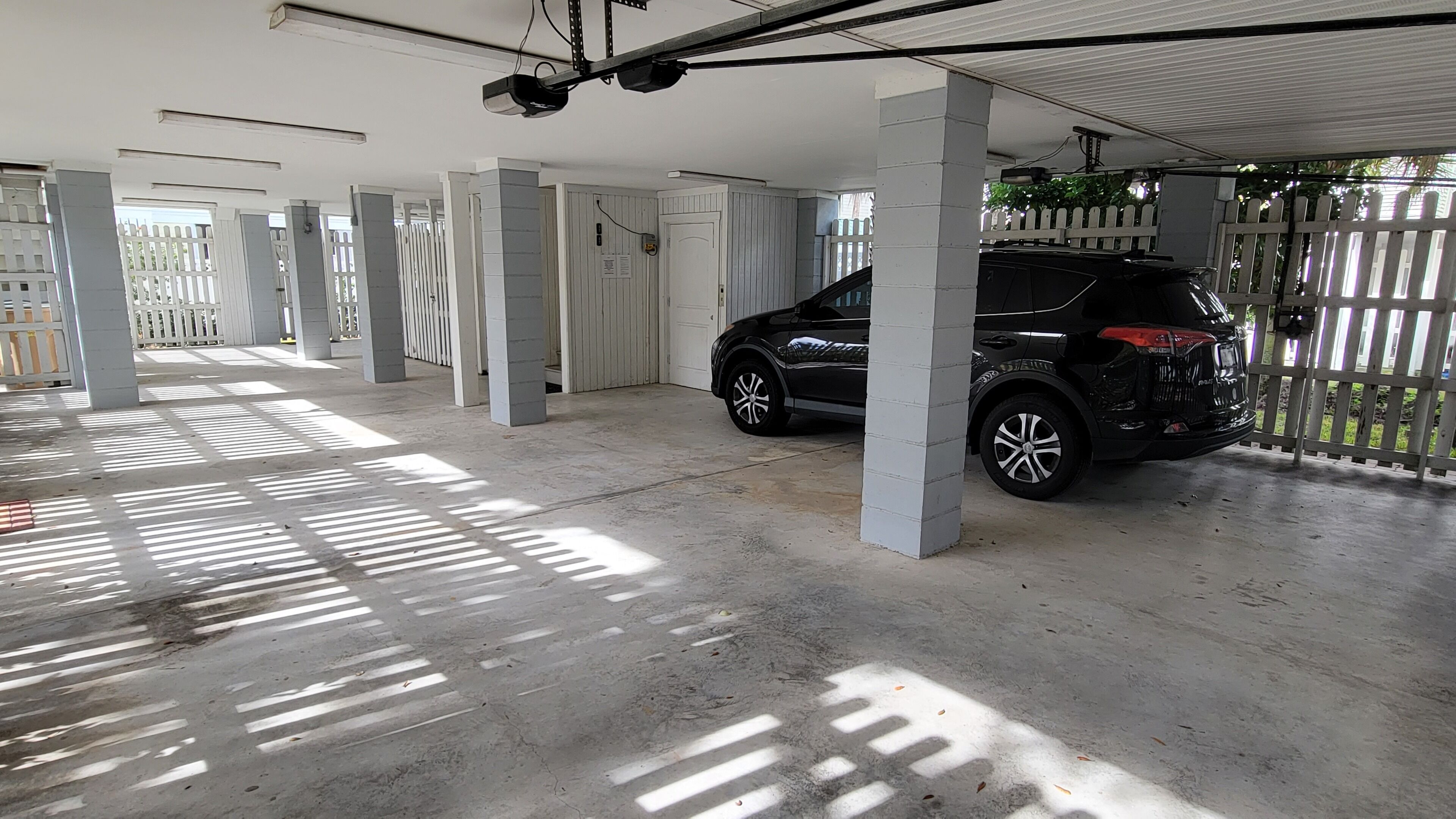 Ett parkeringsgarage med betonggolv och vita pelare.