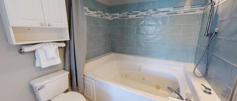 Un baño con bañera, inodoro y ducha.