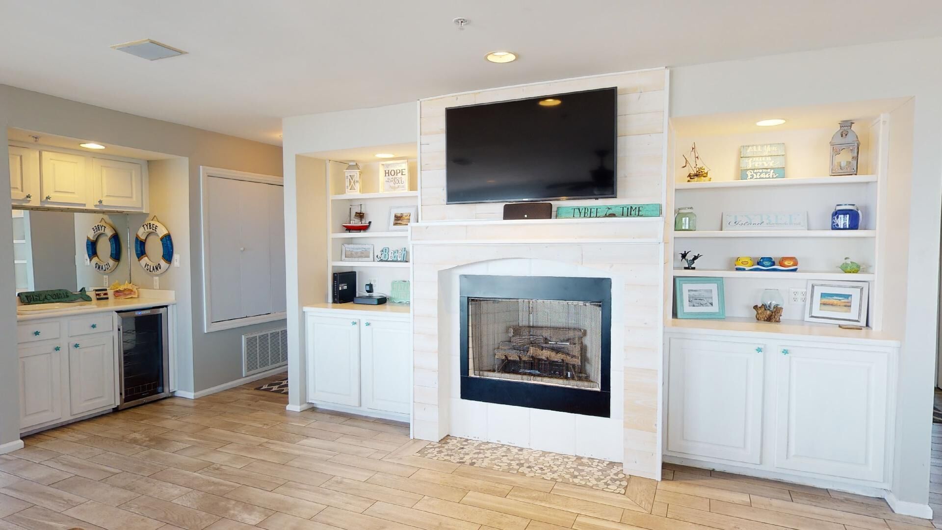 A modern living room with a fireplace, built-in shelves, and a flat-screen TV.