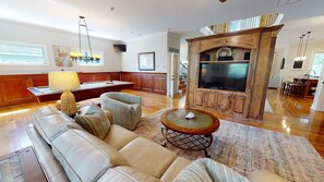 A spacious living room with a large sofa, a coffee table, and a fireplace. - The Pelican House by Tybee Vacation Rentals (Tybee Island)