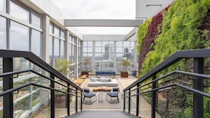 A modern outdoor lounge area with a staircase, seating, and a view of the city. - Apt w/ Balcony & View, 280m From the Metro Hbw2317 (São Paulo)