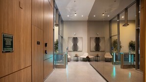 A modern hotel lobby with wooden paneling, a reception desk, and seating areas. - Apt w/ Balcony & View, 280m From the Metro Hbw2317 (São Paulo)