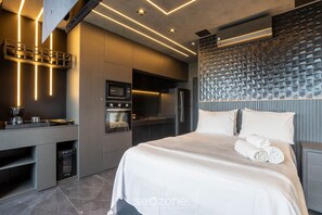 A modern hotel room with a bed, a built-in desk with a microwave, a refrigerator, and a built-in oven. - Apt w/ Balcony & View, 280m From the Metro Hbw2317 (São Paulo)