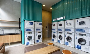 A laundry area with multiple washing machines labeled 'SECA' and 'LAVA'. - Comfort at Helbor Wide - Reboucas - Hbw2317 (São Paulo)