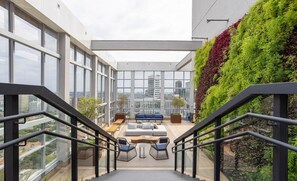 A modern outdoor lounge area with a staircase, seating, and a view of the city. - Apt w/ Balcony & View, 280m From the Metro Hbw2317 (São Paulo)