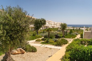 A resort with a pathway leading to a building, surrounded by greenery and cacti. - GuestHost - Charming 40 sqm apartment, able to accommodate up to 4 people, located within the renowned Borgo 84 residence, featuring two swimming pools and a bike path. The property is located just 3 km from the center of Marzamemi, one of the most fasci (Pachino)