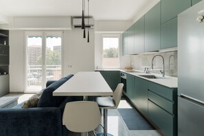 Una cocina moderna con comedor, sofá y vista al exterior.