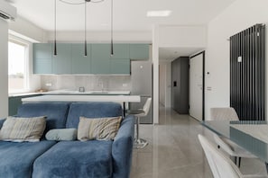 A modern kitchen with teal cabinets, a white countertop, and pendant lighting. - GuestHost - Modern Apartment MM3 Corvetto Milano (Milan)