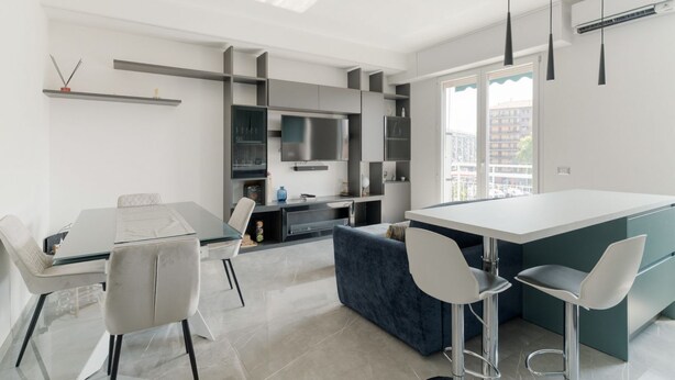 Une cuisine moderne dotée d’un îlot central, d’appareils électroménagers intégrés et d’une grande fenêtre.