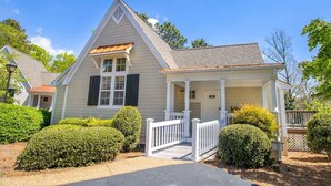 A single-story house with a front porch, a small attached garage, and a well-maintained front yard with trimmed bushes.