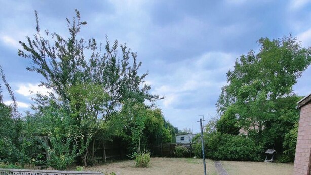 A paved patio area with two outdoor tables and chairs, surrounded by lush greenery and a brick wall. - The Croft House Near Birmingham Airport and Nec (Birmingham)