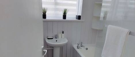 Tina con regadera, tina profunda, amenidades de baño gratuitas, toallas