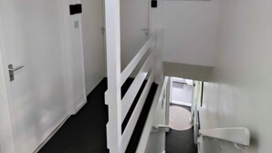 A hallway with white doors numbered 1 to 3, a staircase with white railings, and a ceiling light fixture. - The Croft House Near Birmingham Airport and Nec (Birmingham)