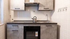 A modern kitchen with a built-in oven, a kettle, and a sink. - Meta Apartment by Wonderful Italy (Bari)