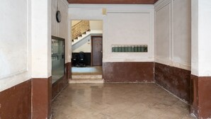 A hallway with a tiled floor, a staircase in the background, and a door at the end. - Meta Apartment by Wonderful Italy (Bari)