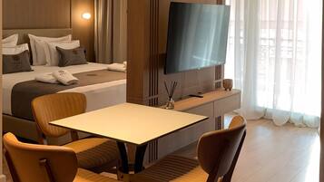 Appartement Deluxe, cuisine, vue fleuve | Coin séjour | TV connectée de 123 cm avec chaßnes numériques