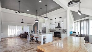 A spacious kitchen with a large island, modern pendant lighting, and a herringbone wood floor. - Beachside 9BR Oasis/Pickle Ball/Infrared Sauna (Sosúa)
