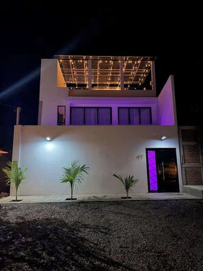A modern two-story building with a flat roof and a balcony.