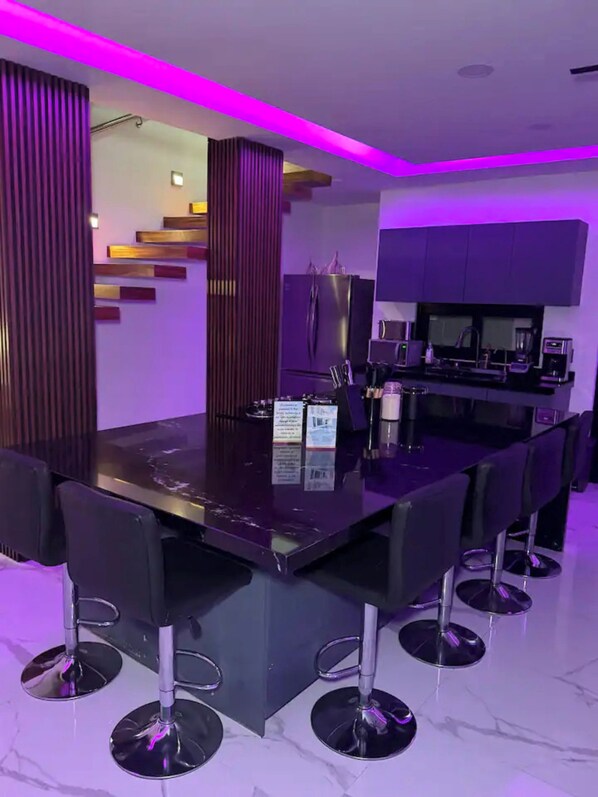 A modern kitchen with a built-in refrigerator, a coffee machine, and a microwave.