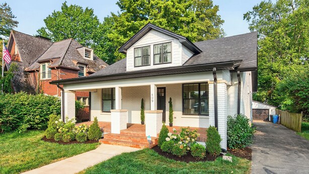 A single-story house with a front porch, a garage, and a well-maintained lawn.
