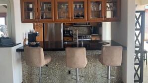 Una cocina moderna con armarios de madera, un refrigerador de acero inoxidable y un salpicadero de azulejos.
