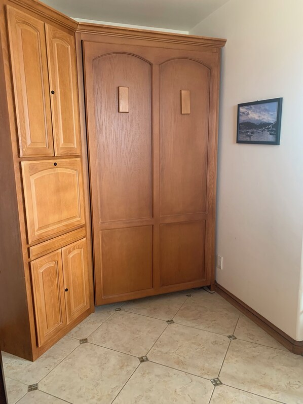 A corner room with wooden cabinets and a tiled floor.