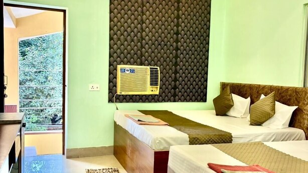 Une chambre à coucher comprenant un lit, une table de chevet, un ventilateur de plafond et un appareil de climatisation.