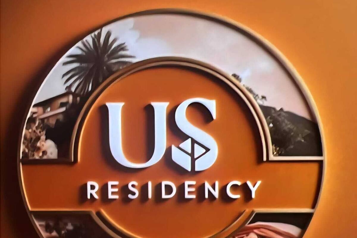 A circular logo with the text "US RESIDENCY" and a partial view of a palm tree and beach scene.
