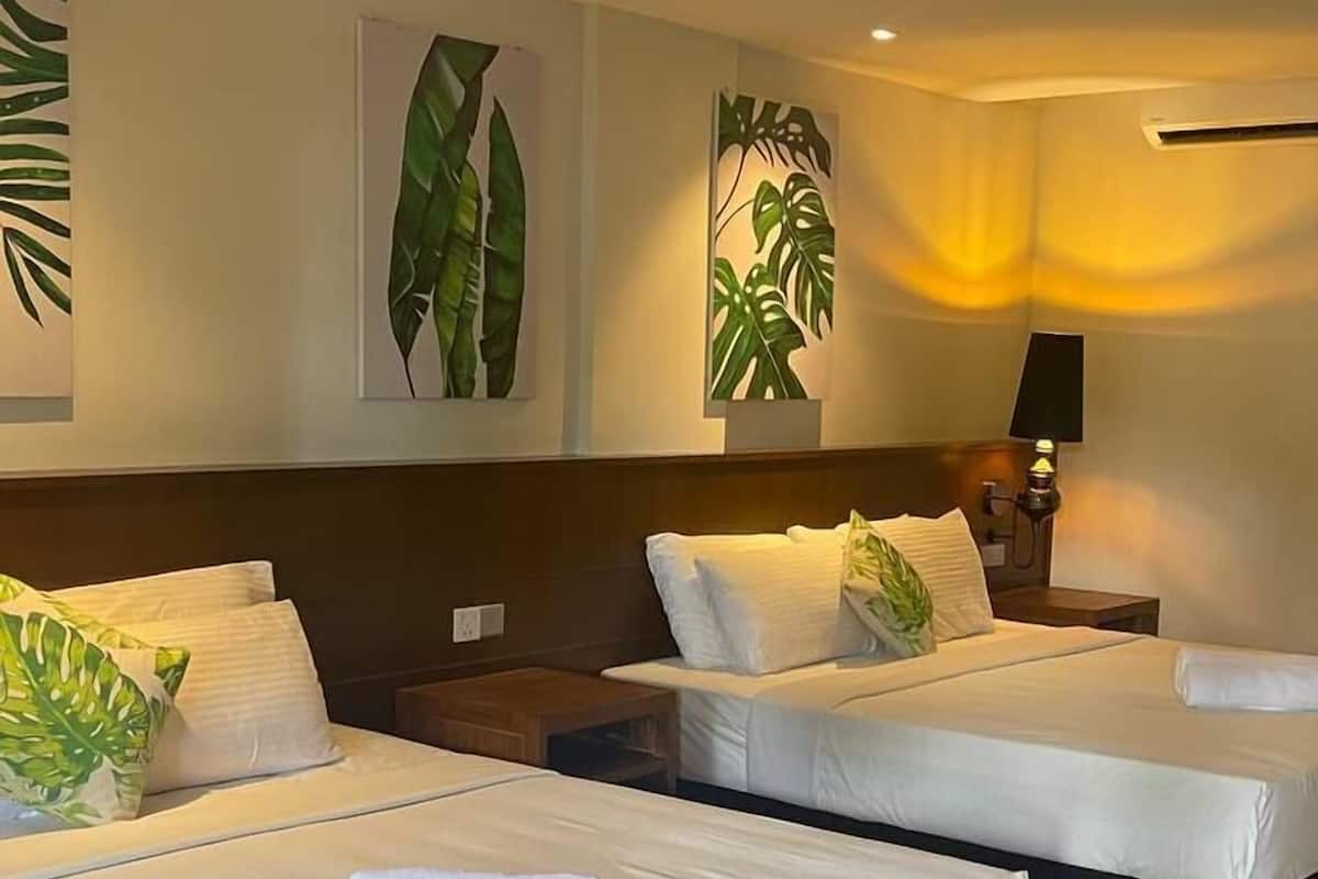Une chambre d’hôtel avec deux lits, un plancher en bois et des œuvres d’art murales.