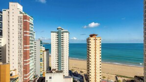 A high-rise hotel with multiple floors, a beach view, and a clear sky. - 3-bedroom Apartment 170m From the Beach Gua1902 (Balneário Camboriú)