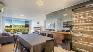 A modern dining area with a large table, chairs, and a wine display. - 3-bedroom Apartment 170m From the Beach Gua1902 (Balneário Camboriú)