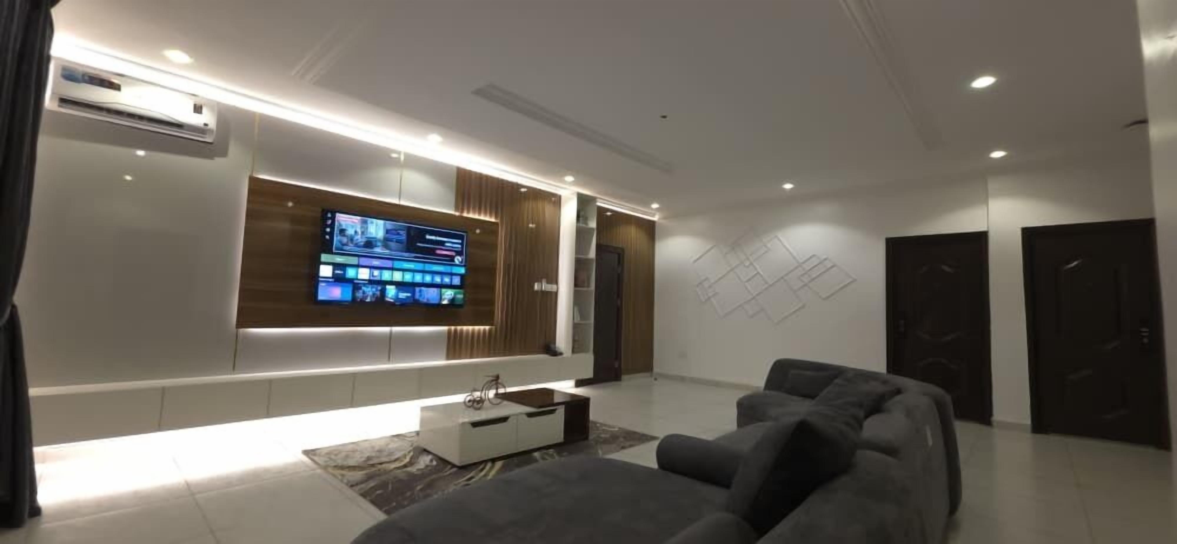 A modern living room with a flat-screen TV, a sofa, and a coffee table.