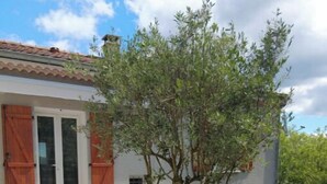 An outdoor patio with a table and chairs, a tree, and a bench. - Spacious "la falaise" house in the beautiful listed village of Balazuc (Balazuc)