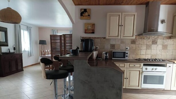 A kitchen with a bar area, a microwave, a stove, and a sink. - Spacious "la falaise" house in the beautiful listed village of Balazuc (Balazuc)