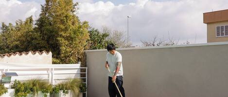 A person cleaning a swimming pool with a mop.