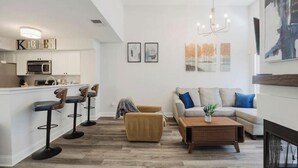 Ein modernes Wohnzimmer mit einer Couch, einem Couchtisch und Barhocker.