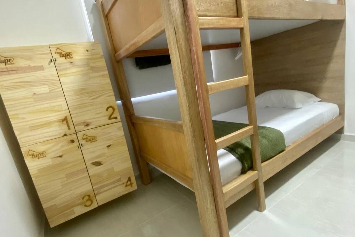 Un lit superposé avec une échelle en bois et un meuble de rangement doté de tiroirs numérotés de 1 à 4.