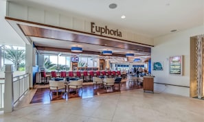 A spacious bar area with a wooden ceiling and a sign reading 'Euphoria.'