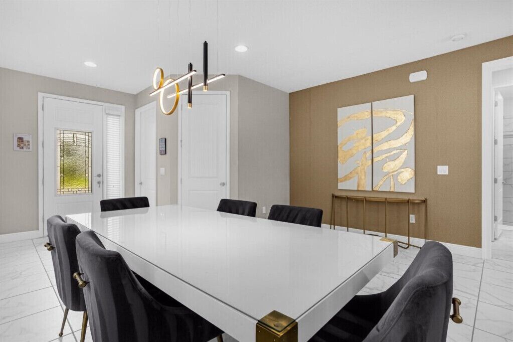 Une salle de conférence avec une longue table, des chaises noires et un lustre moderne.
