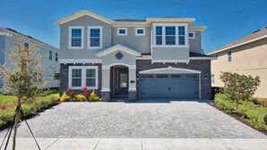 A two-story house with a garage, a driveway, and a well-maintained lawn.