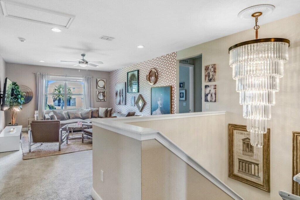 A modern living room with a sofa, coffee table, and a chandelier.